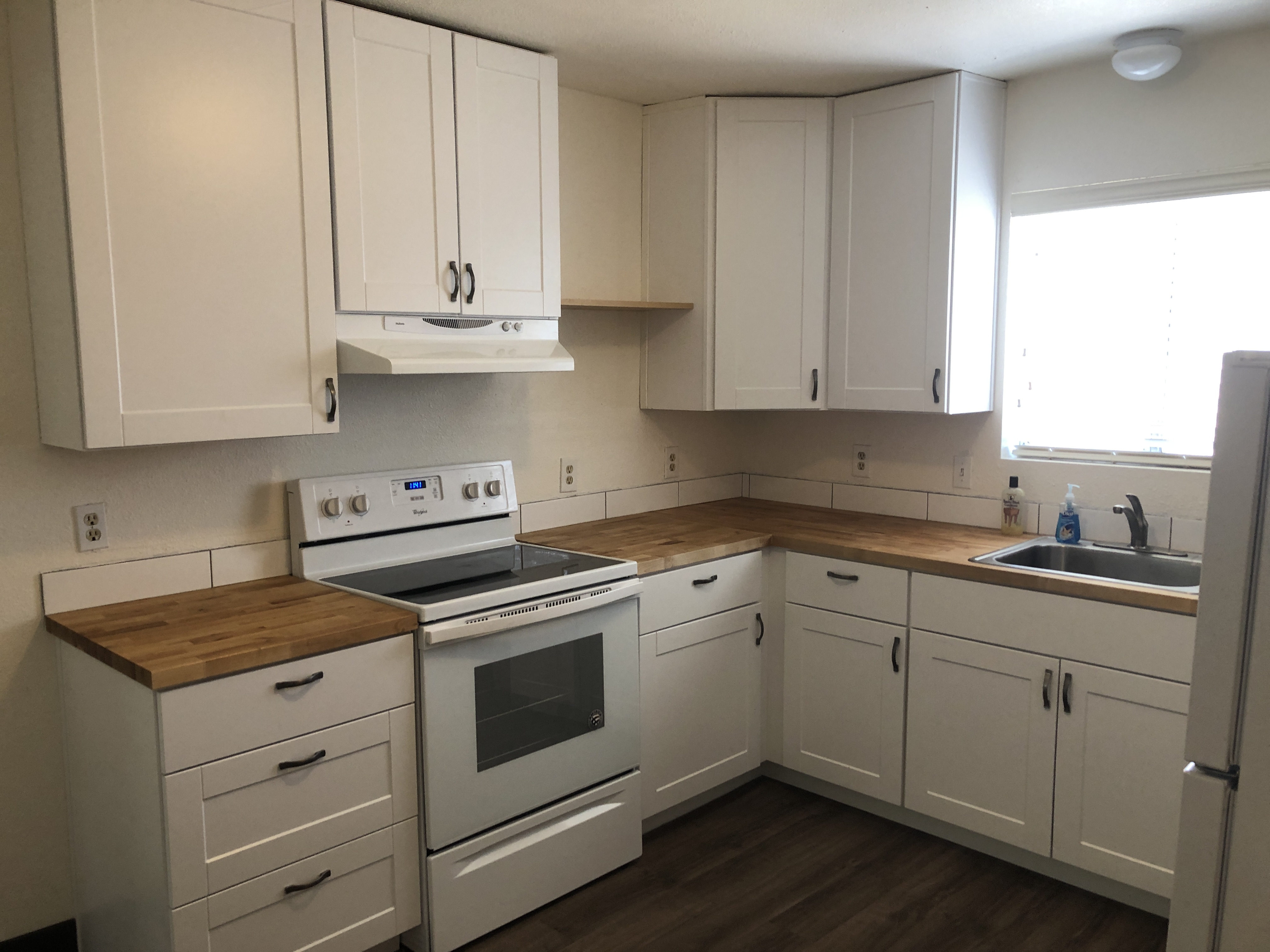Kitchen remodel with white shaker cabinets and butcher block counters